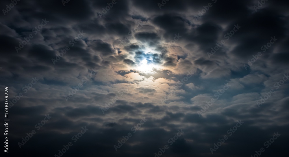 Obraz premium 厚く重く垂れ込める鉛色の雲間から神々しい光が力強く降り注ぎ空全体を瞬く間に劇的に照らし出すその幻想的で神秘的な光景は見る者を圧倒し自然の壮大さと希望に満ちた美しい感覚を深く与える. AI Generated