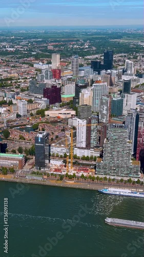 Spectacular 4K vertical aerial video of Rotterdam skyline with modern skyscrapers, waterfront, and ships. Stunning drone footage capturing Dutch city architecture and harbor, perfect for mobile reels.
