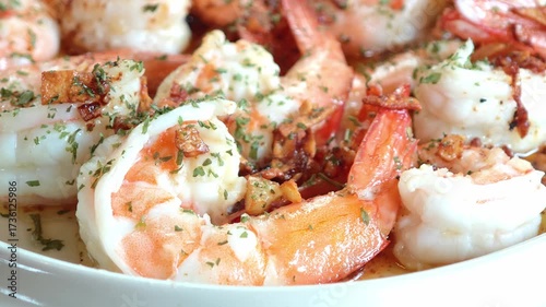 Fried shrimp seasoned with fried garlic, seasoned with sauce and oregano powder on the plate.