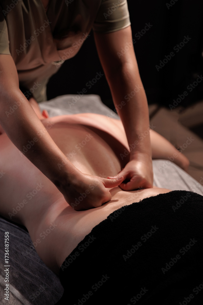 Fototapeta premium Lower back massage therapy. Professional wellness treatment for pain relief, relaxation, and muscle recovery.