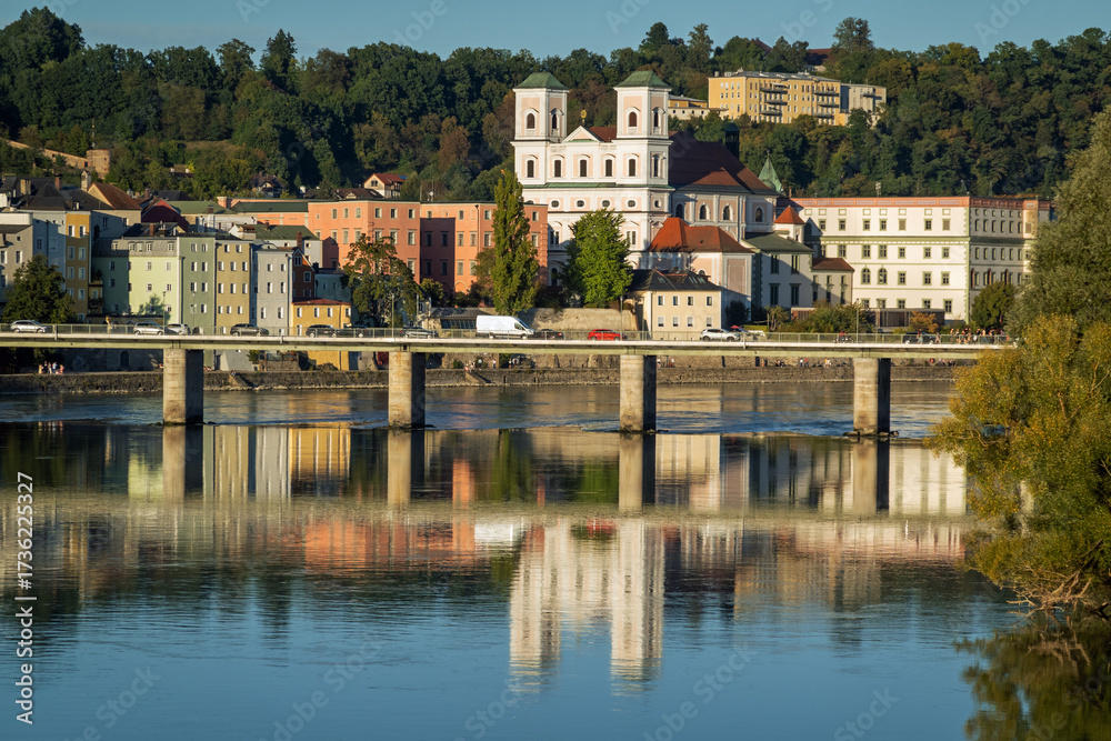 Obraz premium Passau, Bavaria, Germany: St Michael church and Marienbrucke reflected in the Inn river on a sunny afternoon in summer