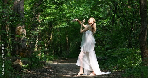 Forest nymph - a young beautiful girl in a white dress posing