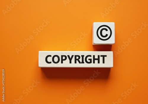 Focused view of wooden blocks displaying copyright symbol and text on vibrant orange background