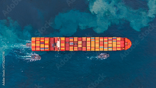 Aerial top view of cargo ships in containers sailing in the sea.
