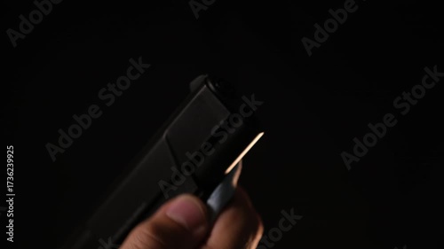 Man's Hand Wiping a Firearm, Dark Background