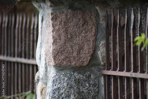 Fence post with metal railing of vertical bars