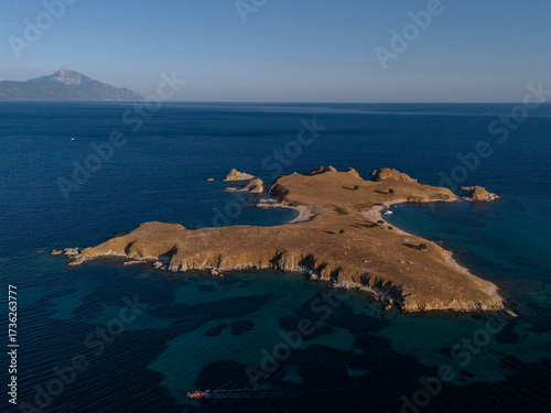Rocky Island and Boat in Deep Blue Coastal Waters Near Athos, Greece