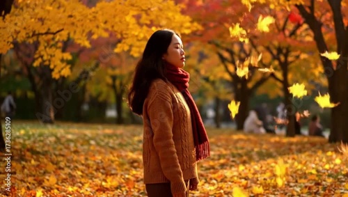 Woman enjoying autumn breeze as leaves fall in vibrant park, perfect for seasonal content, wellness campaigns, and fall lifestyle promotions