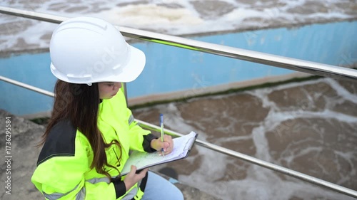 Engineer inspecting wastewater treatment plant and recording data for environmental monitoring. Concept of water management, industrial inspection, and sustainability process.