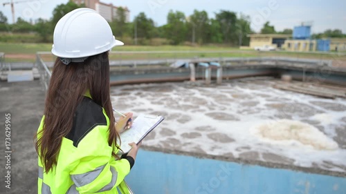 Engineer inspecting wastewater treatment plant and recording data for environmental monitoring. Concept of water management, industrial inspection, and sustainability process.