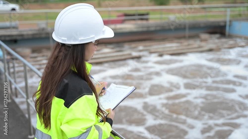 Engineer inspecting wastewater treatment plant and recording data for environmental monitoring. Concept of water management, industrial inspection, and sustainability process.