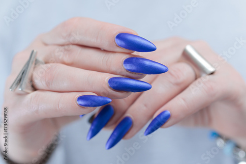 Woman's beautiful hand with long nails and blue nail polish
