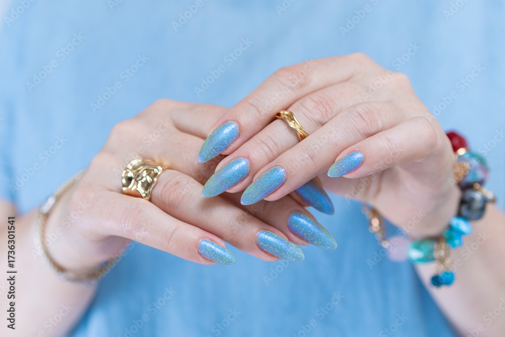 Fototapeta premium beautiful hand with long nails and light baby blue manicure 