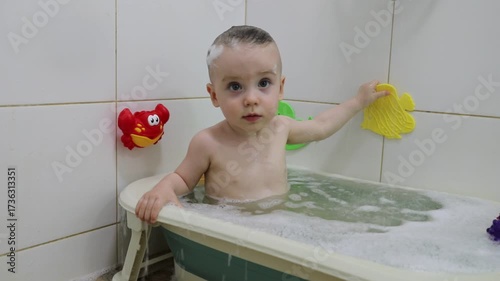 Baby girl bathes in a baby bathtub