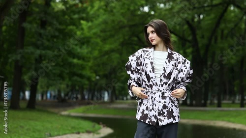 A young beautiful brunette girl poses in a stylish jacket