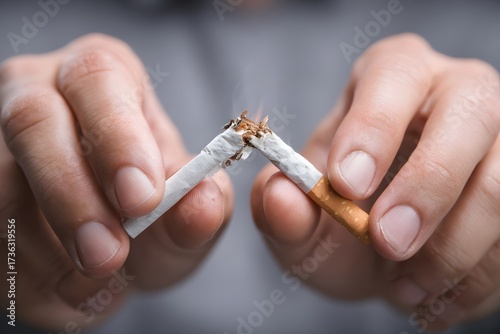 Mann bricht Zigarette in zwei Teile als Symbol für Rauchstopp
