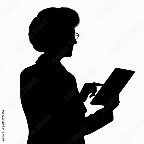 Silhouette of elderly woman using tablet while standing indoors  