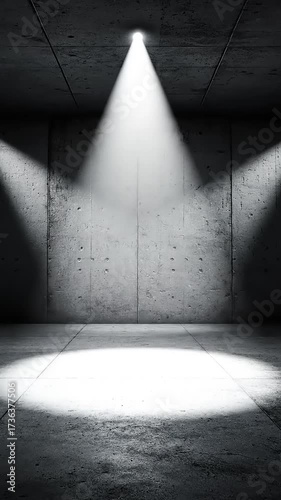 Dramatic lighting in an industrial space with concrete walls and a spotlight on the floor