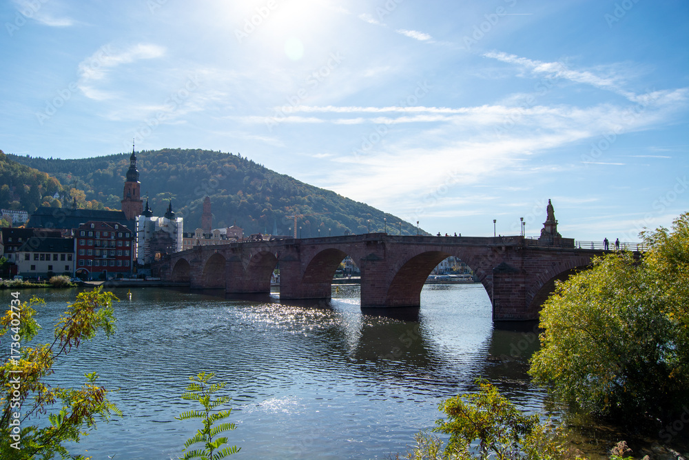 Fototapeta premium Historic stone bridge over river with scenic backdrop