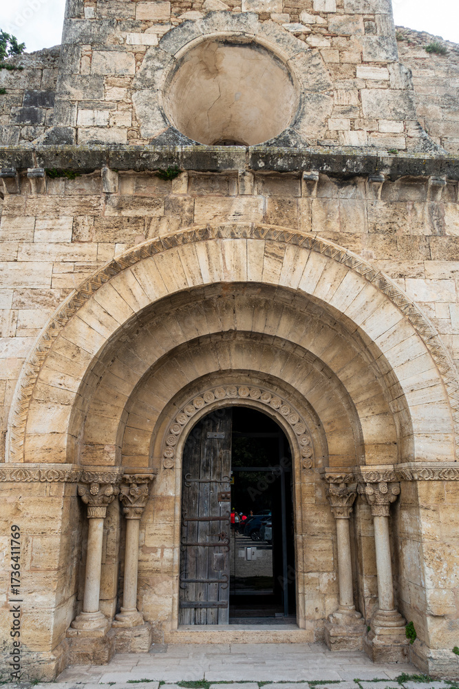 Fototapeta premium The main portal and oculus window of the 12th-century Romanesque church of Santa Maria de Porqueres. Catalonia, Spain.