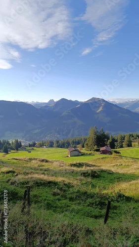 Majestic mountain view in Tirol showcasing lush green hills and rustic homes in the peaceful countryside at noon