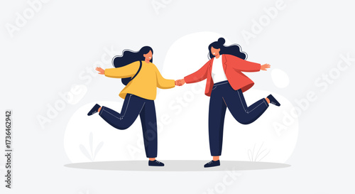 Two young women holding hands while running with smiles on their faces in a park.