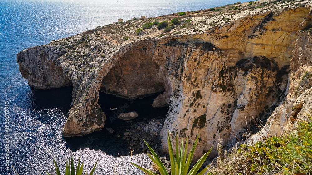 custom made wallpaper toronto digitalSheer cliffs with natural arch and shadowed sea cave above clear blue water, wild coastal scenery