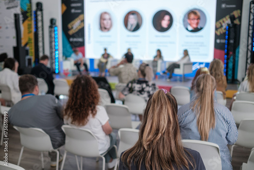 Wallpaper Mural Audience attends conference panel discussion with speakers on stage in modern venue, bright screens, blue lighting Torontodigital.ca