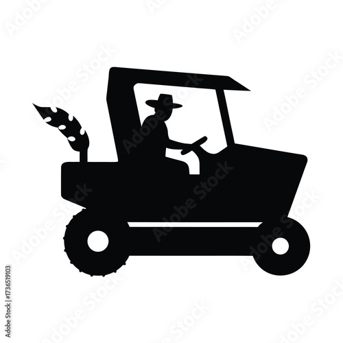 Silhouette of a farmer driving a tractor with a harvested crop in the back