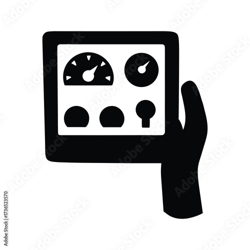 Silhouette of a hand holding a tablet displaying various gauges and controls