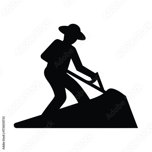 Silhouette of a farmer wearing a hat digging with a shovel in a field