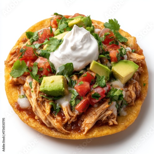 Delicious crispy chicken tostada loaded with fresh avocado tomatoes and sour cream isolated