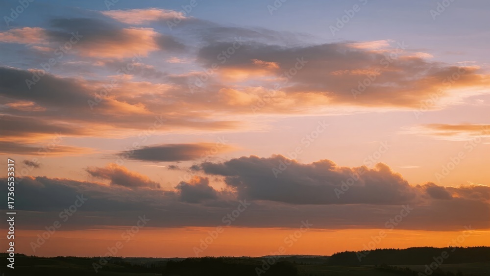 Fototapeta premium A vibrant sunset with orange and pink hues illuminating the sky above a distant horizon.