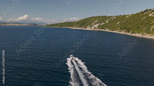 4K drone aerial of a boat speeding across the turquoise Adriatic Sea near the Croatian coast, leaving a white water trail in summer scenery. Taken on 27.09.2025 in Dramalj, Croatia.