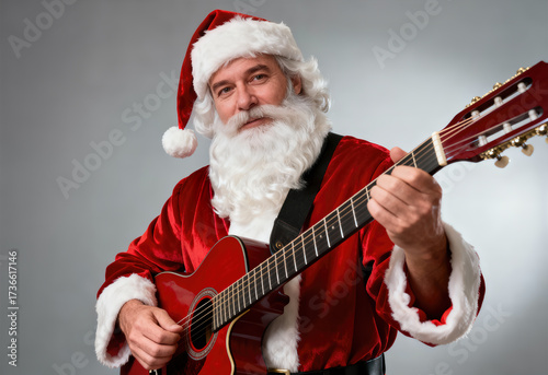 Santa Claus playing red acoustic guitar on gray background