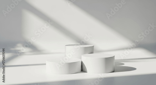 Minimalist white cylindrical pedestals casting elegant shadows on a clean studio background creating a serene and modern product display