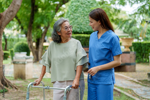 Caregiver provides assistance and support to senior in park, fostering warm connection while ensuring individual receives care needed for fulfilling life