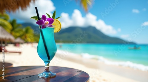 Refreshing blue cocktail on a tropical beach with ocean and mountain background