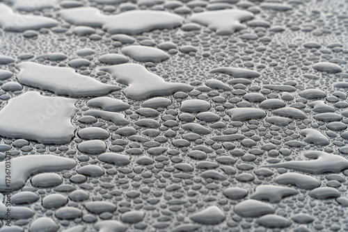 Fotografie Close-up of water droplets demonstrating the hydrophobic effect on a car surface after applying a ceramic coating
