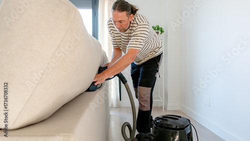 Man cleaning sofa using non-chemical ionized water method
