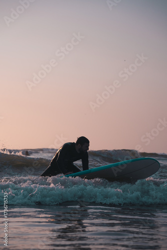 Photography Surfing scene at sunset, man surfing with a foam surf board