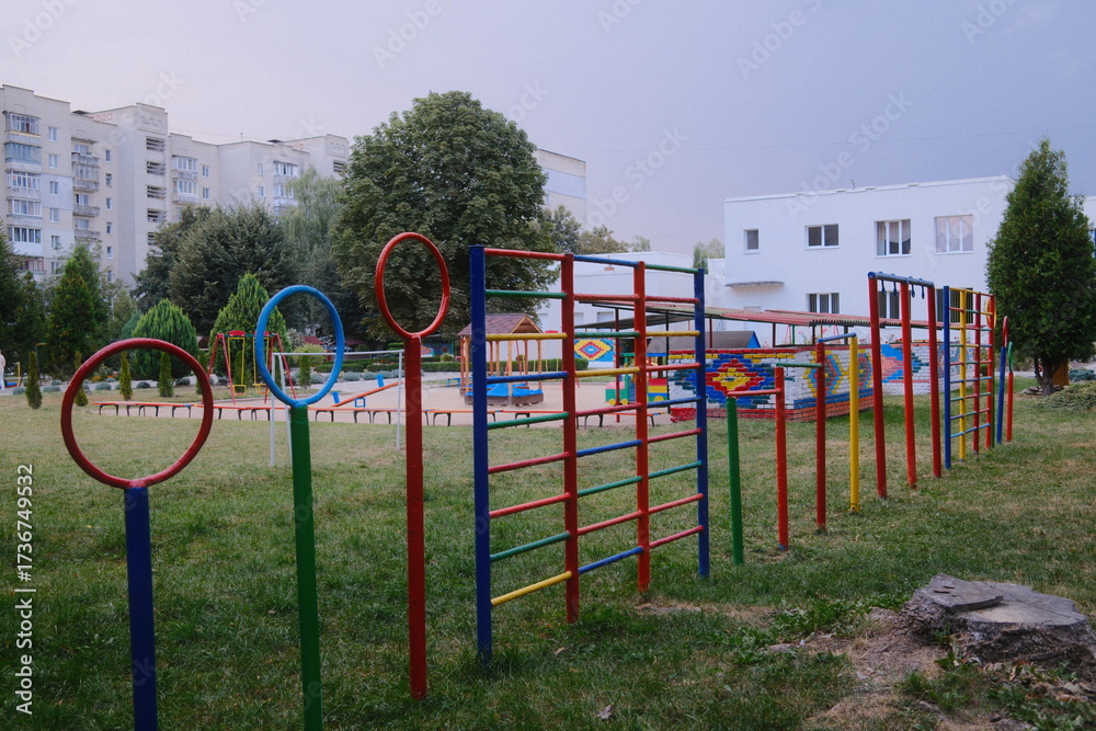 Fototapeta premium Outdoor play area with colorful equipment stands on the green grass.