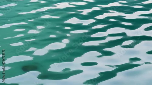 Calm water ripples reflecting sunlight in a serene ocean setting near the shore on a clear day