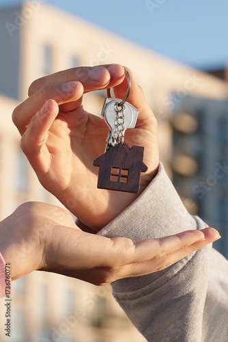 Принти на полотні Close up of property owner handing over house key with home shaped keychain to female client in front of apartment building