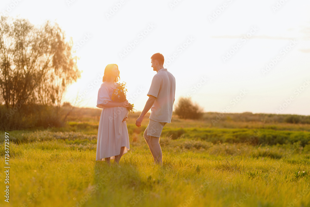 Fototapeta premium Couple holding hands in a sunlit field, sharing a tender moment together during sunset