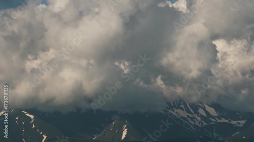 Beautiful mountain landscape. High-mountain massif, clouds over mountain peaks. Mountain slope inside a cloud, nature at a height