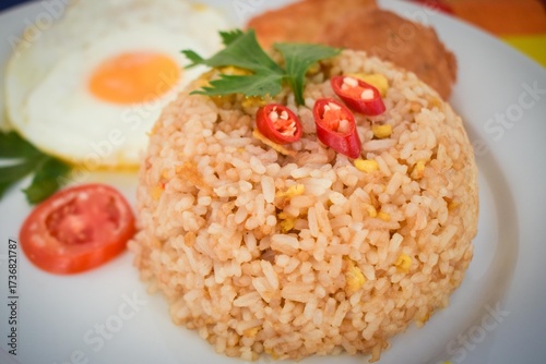 Traditional Indonesian Fried Rice with Fried Egg on White Plate.