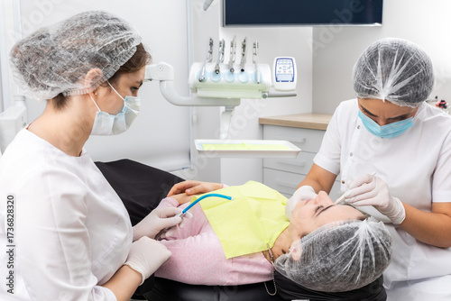 Φωτογραφία Dentist and assistant performing dental treatment inmodern dental clinic, patien