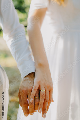 Close-up of bride and groom hands with gold wedding rings, showing love, marriage, and lifelong commitment