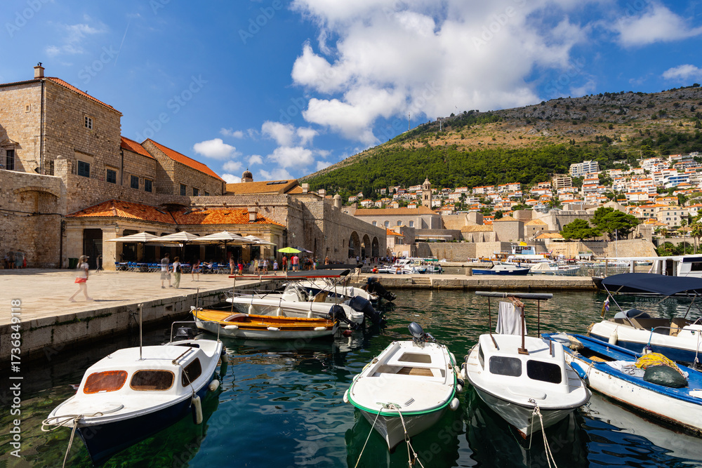 Obraz premium Small port of Dubrovnik city in Croatia. Boats and launches against the backdrop of a medieval fortress in Europe